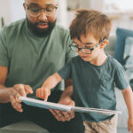 Father and Son looking at book together
